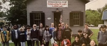 A group of students from Salisbury Central School District posing in front of the Irondale Schoolhouse.